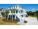 Elegant two-story coastal home featuring a charming entryway staircase and lush landscaping at 4176 Victory Pointe Dr, Mount Pleasant, SC 29466