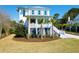 Beautiful two-story beach house with white siding, a charming front porch, and well-manicured lawn at 4176 Victory Pointe Dr, Mount Pleasant, SC 29466