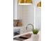 Kitchen sink with stainless steel faucet, cutting board, brass hardware and brick backsplash at 4176 Victory Pointe Dr, Mount Pleasant, SC 29466