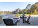 An inviting outdoor patio features a fire pit and comfortable lounge chairs, set against a tranquil waterfront backdrop at 4176 Victory Pointe Dr, Mount Pleasant, SC 29466