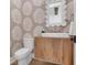 Unique powder room with wood vanity and leaf wallpaper at 4176 Victory Pointe Dr, Mount Pleasant, SC 29466