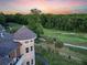 Aerial view of the home with a turret and golf course in the distance at sunset at 4202 Links Ct, North Charleston, SC 29420