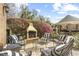 This backyard features an outdoor grill, stone patio, flowering bushes, and an outdoor cabana at 4202 Links Ct, North Charleston, SC 29420