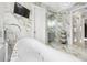 This stunning bathroom includes a jacuzzi tub, television, marble walls, modern shower and vanity area at 4202 Links Ct, North Charleston, SC 29420