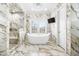 Luxurious bathroom featuring a soaking tub, marble walls, and a glass-enclosed shower at 4202 Links Ct, North Charleston, SC 29420