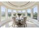 Bright dining area surrounded by large windows, chandelier, and beautiful garden views at 4202 Links Ct, North Charleston, SC 29420