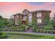 Grand brick home with manicured landscaping, winding stairs, and lush green surroundings at sunset at 4202 Links Ct, North Charleston, SC 29420