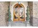 Grand double front door with elegant, circular glass, and decorative topiaries at 4202 Links Ct, North Charleston, SC 29420