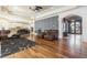 Spacious living room with hardwood floors, leather sofas, decorative wallpaper, and an arched entryway at 4202 Links Ct, North Charleston, SC 29420