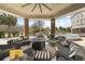 Expansive covered patio with comfortable seating, a cozy fire pit, and views of the lush garden and pool at 4202 Links Ct, North Charleston, SC 29420