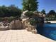 Backyard pool with rock waterfall feature, surrounded by trees at 4202 Links Ct, North Charleston, SC 29420
