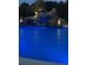 Lounge by the lit pool with a charming waterfall surrounded by lush landscaping at twilight at 4202 Links Ct, North Charleston, SC 29420