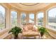 Cozy sunroom featuring curved walls, large windows offering views of the landscaped yard, and comfortable seating at 4202 Links Ct, North Charleston, SC 29420