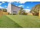 Spacious backyard with a view of the back of the house surrounded by a wooden fence and green grass at 422 Sanders Farm Ln, Charleston, SC 29492