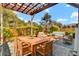 Inviting backyard patio underneath a pergola with outdoor dining and separate seating area surrounded by lush landscaping at 422 Sanders Farm Ln, Charleston, SC 29492