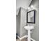 Pedestal sink in a bathroom with grey walls, black framed mirror, and modern lighting at 422 Sanders Farm Ln, Charleston, SC 29492