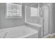 Bathroom featuring a white soaking tub next to a glass enclosed shower and window at 422 Sanders Farm Ln, Charleston, SC 29492