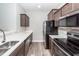 Modern kitchen with stainless steel appliances, dark wood cabinets, and white countertops at 522 Truman Dr, Goose Creek, SC 29445
