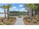 A brick firepit with lake view surrounded by palm trees and green space at 532 Fern Tree Dr, Summerville, SC 29486