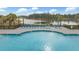 An outdoor pool with lounge chairs and palm trees, overlooking a serene lake at 532 Fern Tree Dr, Summerville, SC 29486