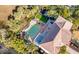Aerial view of backyard oasis with pool, spa, deck, patio, turf, and outdoor seating for entertaining at 65 Ocean Point Dr, Isle of Palms, SC 29451
