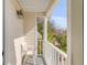 Outdoor balcony with white railings features seating and a view of lush tropical landscaping at 65 Ocean Point Dr, Isle of Palms, SC 29451