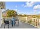 View of an outdoor deck with seating and railing, overlooking the marsh, trees, and nearby homes at 65 Ocean Point Dr, Isle of Palms, SC 29451