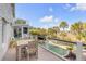 Inviting deck with dining area overlooking a pool and lush landscaping at 65 Ocean Point Dr, Isle of Palms, SC 29451