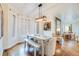 Dining area showcasing a white table with bench seating, modern chandelier, and light-filled bay windows at 65 Ocean Point Dr, Isle of Palms, SC 29451