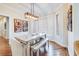 Cozy dining area with views, featuring a farmhouse table, decorative lighting, white shutters, and hardwood flooring at 65 Ocean Point Dr, Isle of Palms, SC 29451