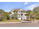 Beautiful multi-story home with a well-maintained yard, stairs leading up to the main entrance, and a three-car garage at 65 Ocean Point Dr, Isle of Palms, SC 29451