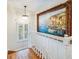 Hallway with decorative painting, stairway and ample natural light at 65 Ocean Point Dr, Isle of Palms, SC 29451