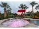 Hot tub under a red umbrella, set amidst tropical palm trees, with an elegant black fence at 65 Ocean Point Dr, Isle of Palms, SC 29451