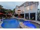 A stunning backyard oasis featuring a pool, hot tub, patio, palm trees, and an outdoor seating area at 65 Ocean Point Dr, Isle of Palms, SC 29451