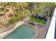 Aerial view of the backyard pool and lounge area surrounded by pavers, chairs, and palm trees at 65 Ocean Point Dr, Isle of Palms, SC 29451