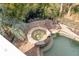 Overhead view of the backyard pool and spa with brick pavers, lounge chairs and palm trees at 65 Ocean Point Dr, Isle of Palms, SC 29451