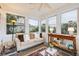 Inviting sunroom with a cozy sofa, decorative table, and lots of natural light flooding through the windows at 65 Ocean Point Dr, Isle of Palms, SC 29451