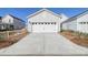 A two-car garage with a concrete driveway, white door, and architectural details on a sunny day at 715 Rumbling Leaf Ln, Summerville, SC 29486