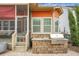 Outdoor kitchen and screened porch with seating overlooking a stone paver patio and backyard at 729 Quintan St, Summerville, SC 29486