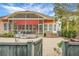 This backyard shows a beautiful screened in porch with a built in outdoor kitchen and firepit area at 729 Quintan St, Summerville, SC 29486