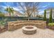 Stone fire pit with built-in seating in a landscaped backyard with a paver patio at 729 Quintan St, Summerville, SC 29486