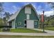 Barn with green siding and white trim surrounded by green grass and a paved path at 729 Quintan St, Summerville, SC 29486