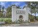 Community entrance sign for Carnes Crossroads surrounded by a beautiful array of flowers and plants at 729 Quintan St, Summerville, SC 29486