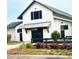 Charming farm store featuring a classic white barn-style design with black accents and lovely landscaping at 729 Quintan St, Summerville, SC 29486