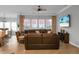 Spacious living room featuring a large brown leather sectional, a ceiling fan, and a view of the backyard at 729 Quintan St, Summerville, SC 29486