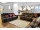 Open-concept living room with brown leather furniture, an area rug, and an adjacent kitchen with white cabinets at 729 Quintan St, Summerville, SC 29486