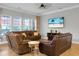 Comfortable living room with large windows, hardwood floors, plush leather seating, and beachy TV display at 729 Quintan St, Summerville, SC 29486
