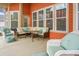 Cozy screened-in porch with wicker furniture, bright turquoise accents, and views of the well landscaped backyard at 729 Quintan St, Summerville, SC 29486