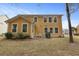 A yellow two-story home with a backyard patio, lawn, mature shrubbery, and outdoor grill at 8592 Sentry Cir, North Charleston, SC 29420