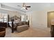 Bright bedroom featuring an ornate bed frame, neutral carpet, and an upholstered storage bench at 8592 Sentry Cir, North Charleston, SC 29420
